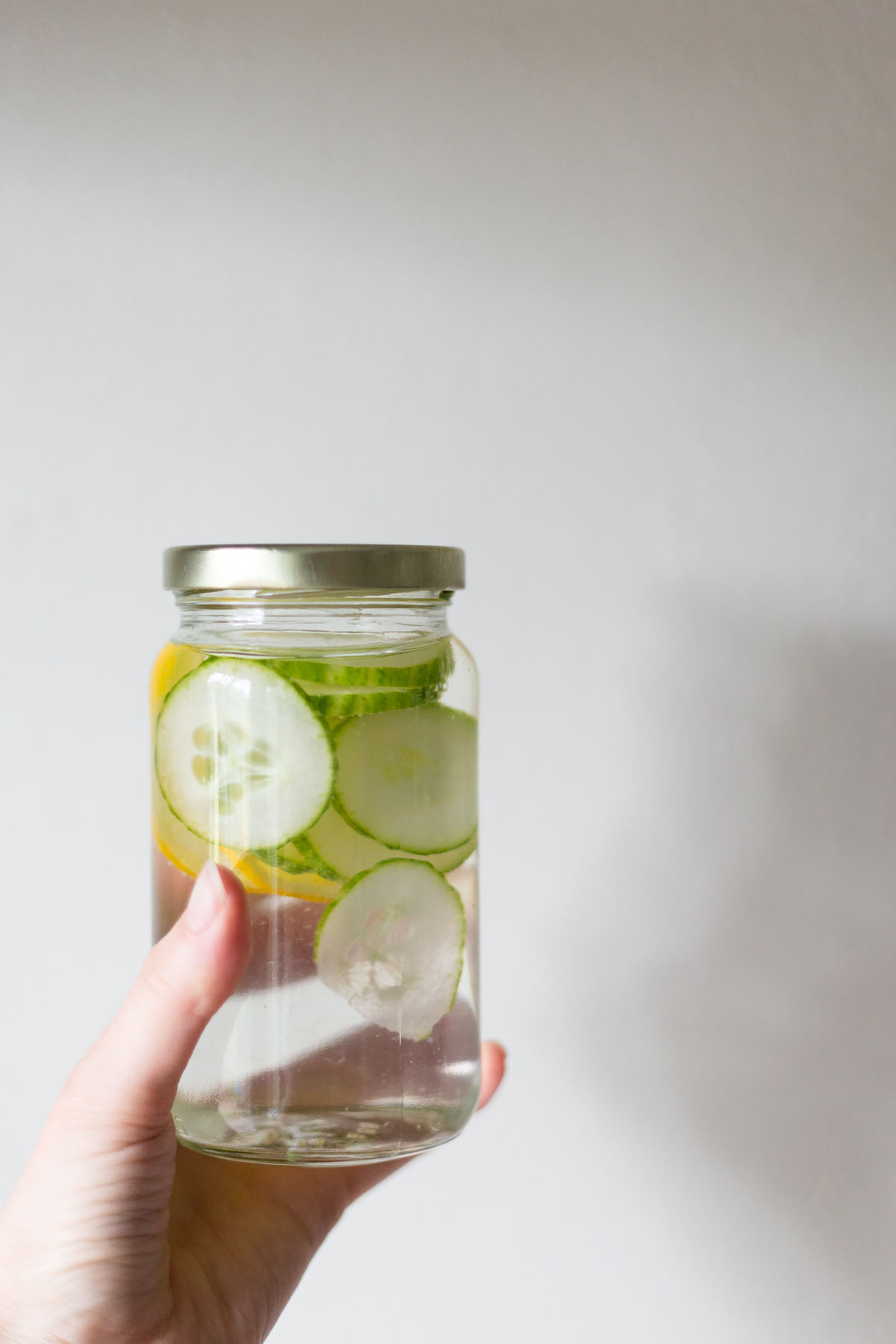 cucumbers and lemons infusing in a jar