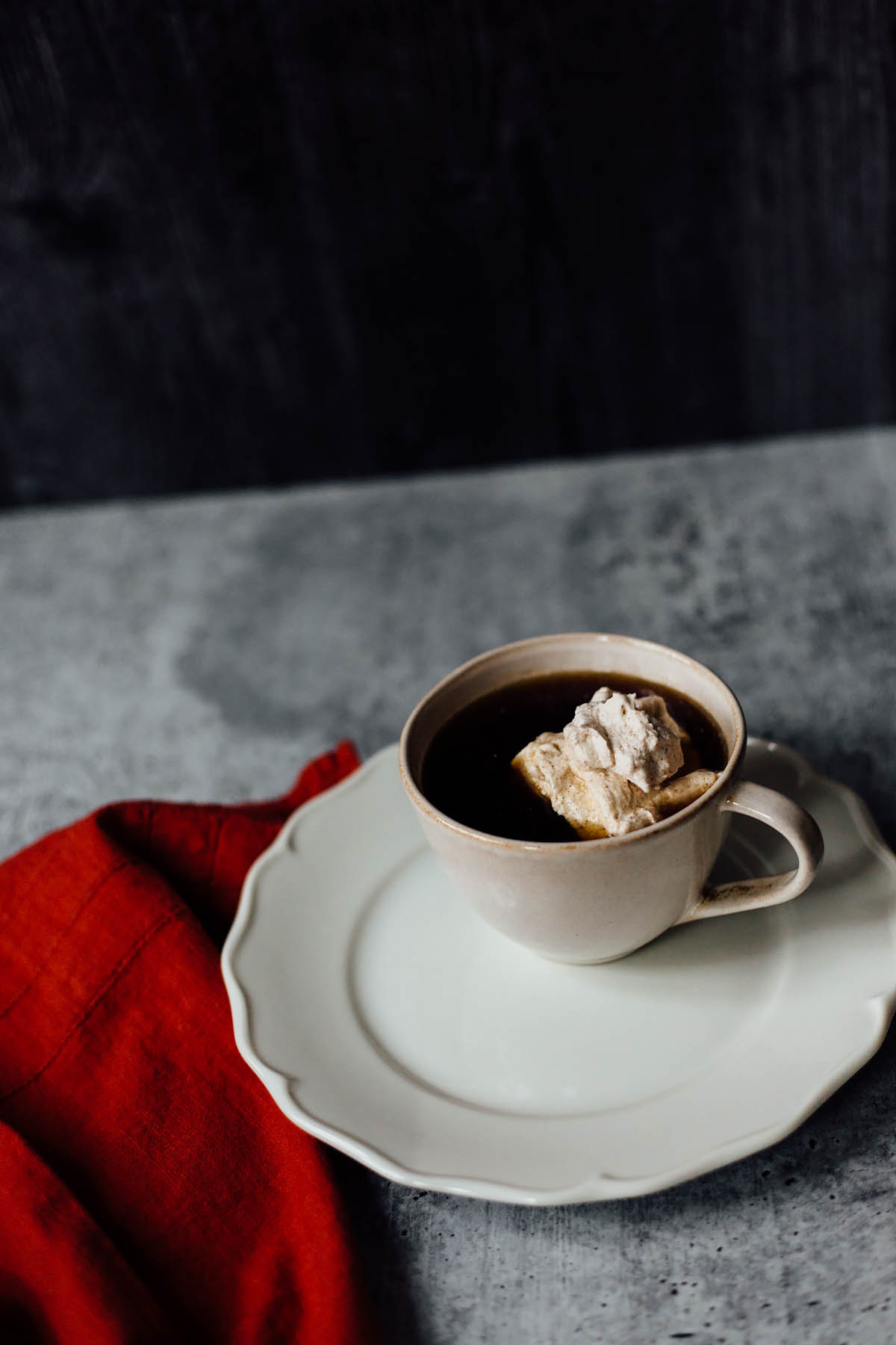 cinnamon whipped cream in coffee with a towel on the side