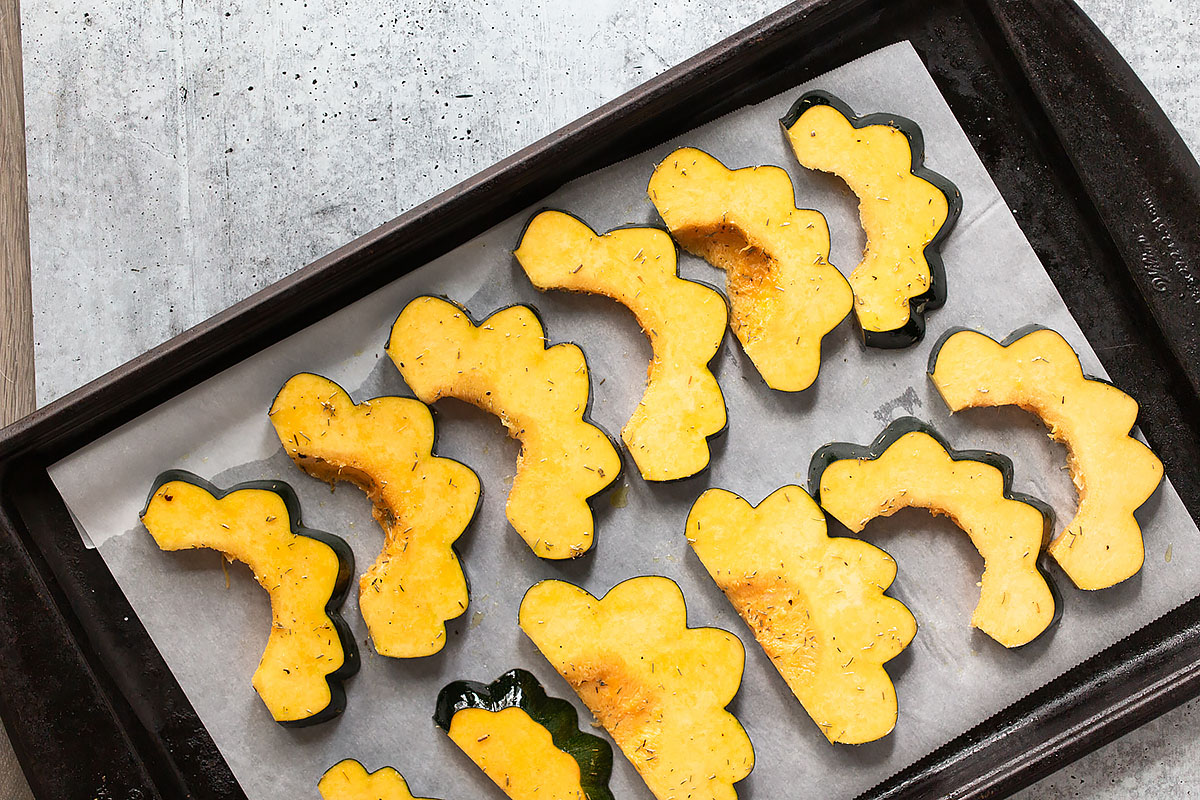 acorn squash slices on a cookie sheet