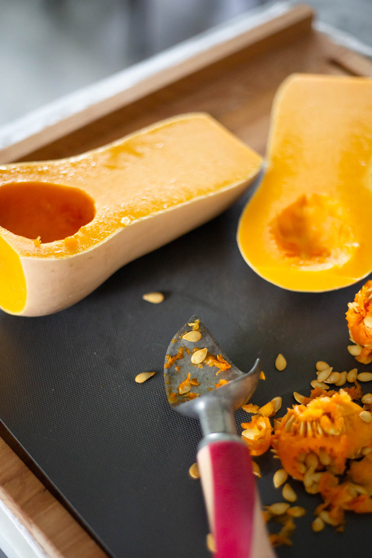 scooping the seeds out of a butternut squash