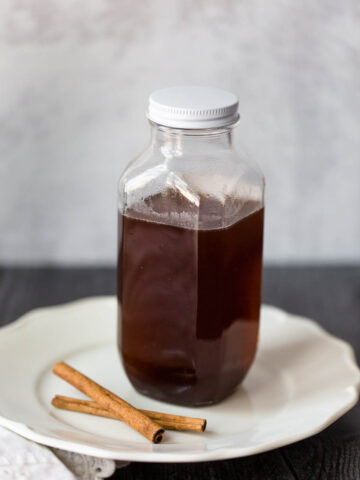 cinnamon simple syrup in a jar with cinnamon sticks on the side