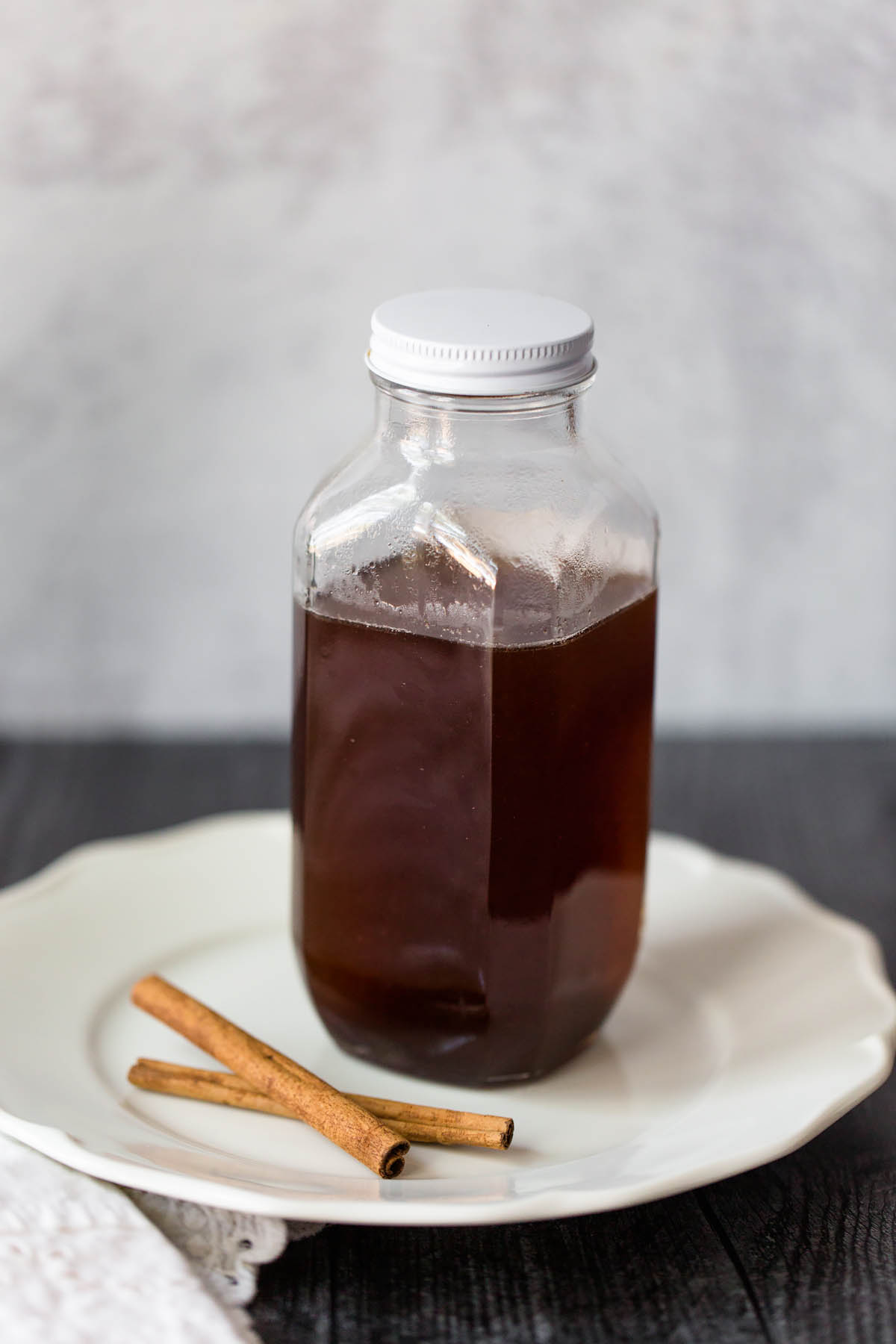 cinnamon simple syrup in a jar with cinnamon sticks on the side