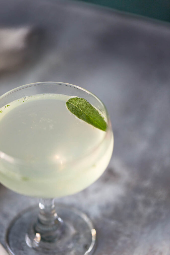 sage gimlet mocktail in a coupe glass up close