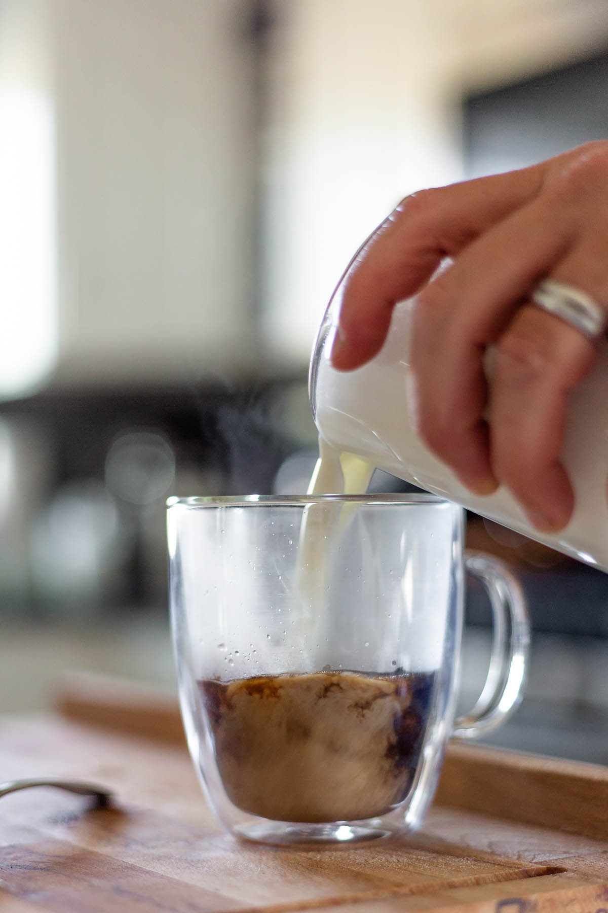 adding milk to a latte