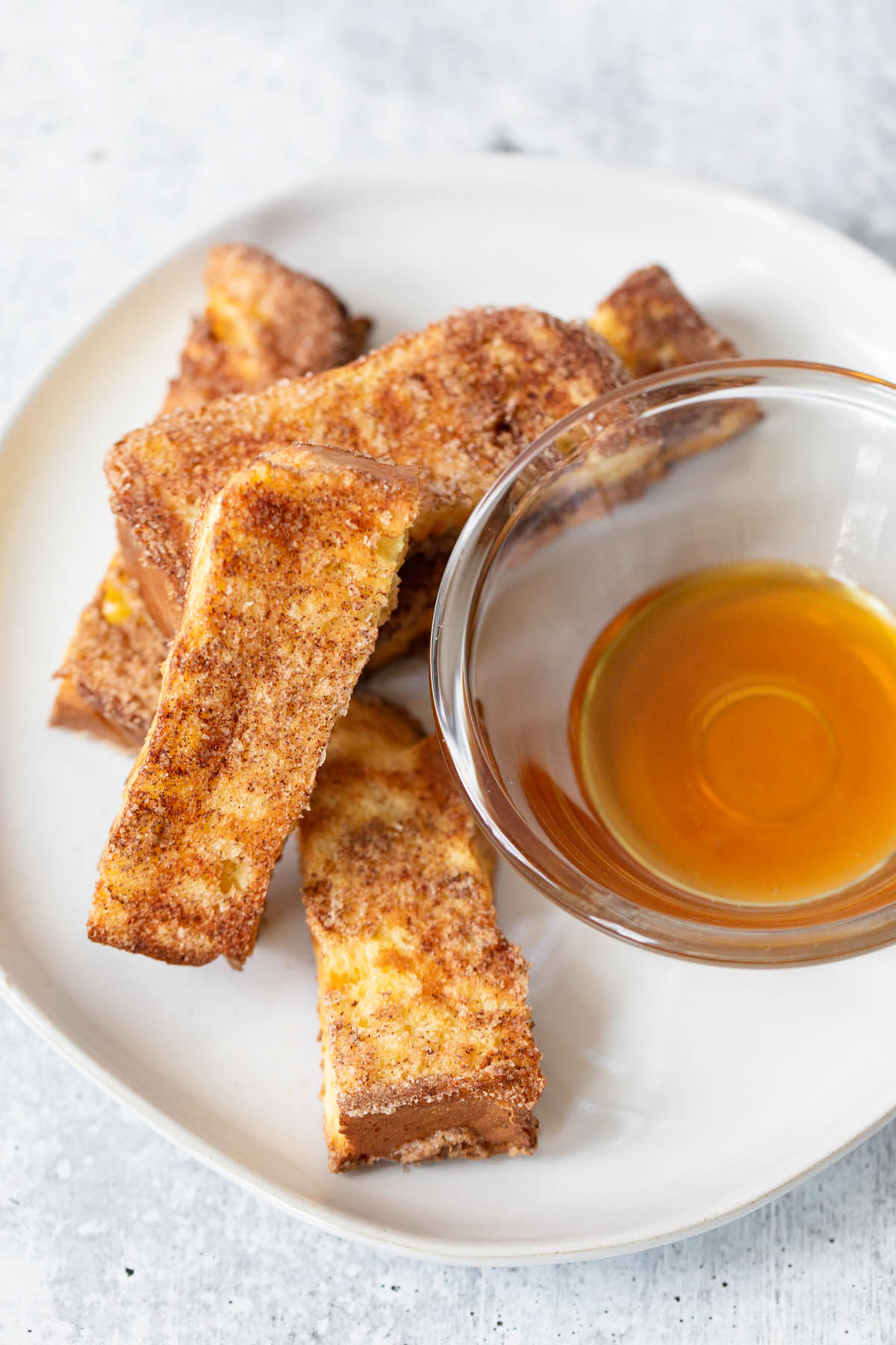 air fryer french toast sticks with a side of syrup