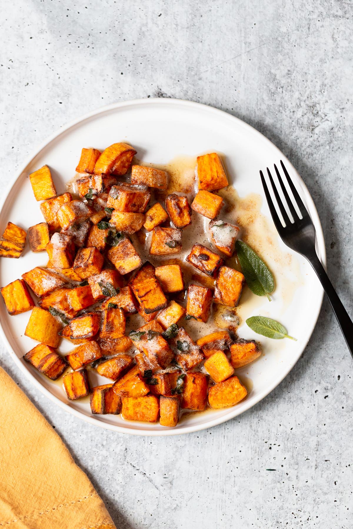 sweet potatoes on a plate with sage leaves