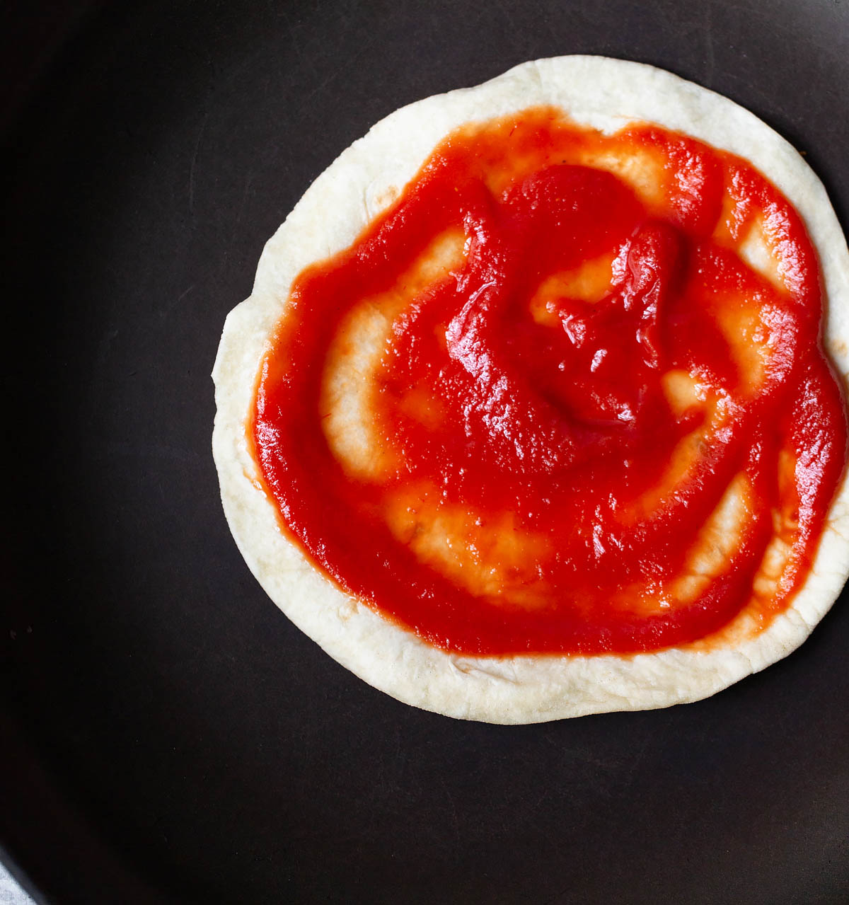 tomato sauce on a tortilla