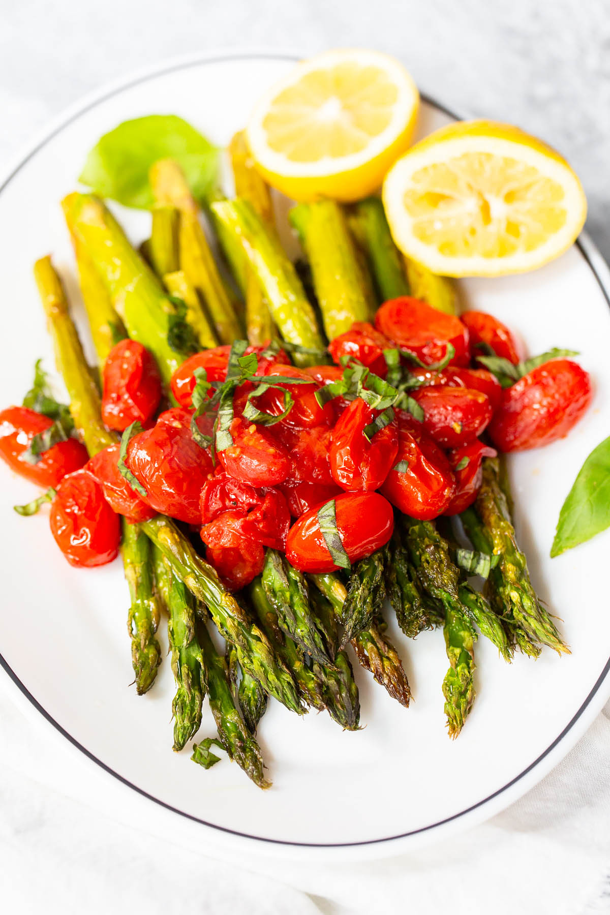 roasted asparagus and blistered cherry tomatoes with fresh basil on top