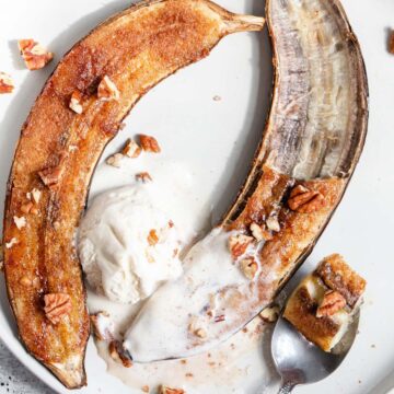 Air fryer banana topped with ice cream and chopped pecans.