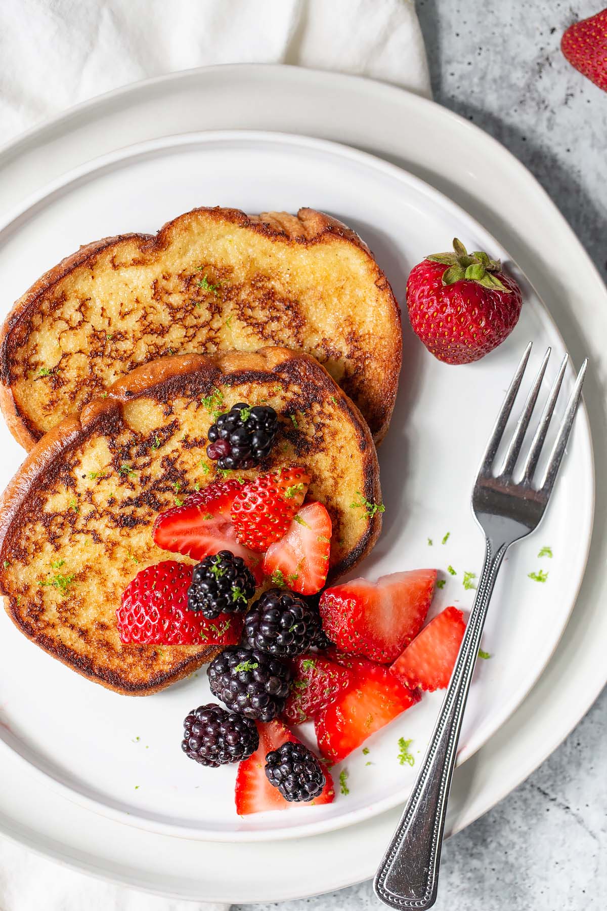 coconut lime french toast topped with blackberries and strawberries