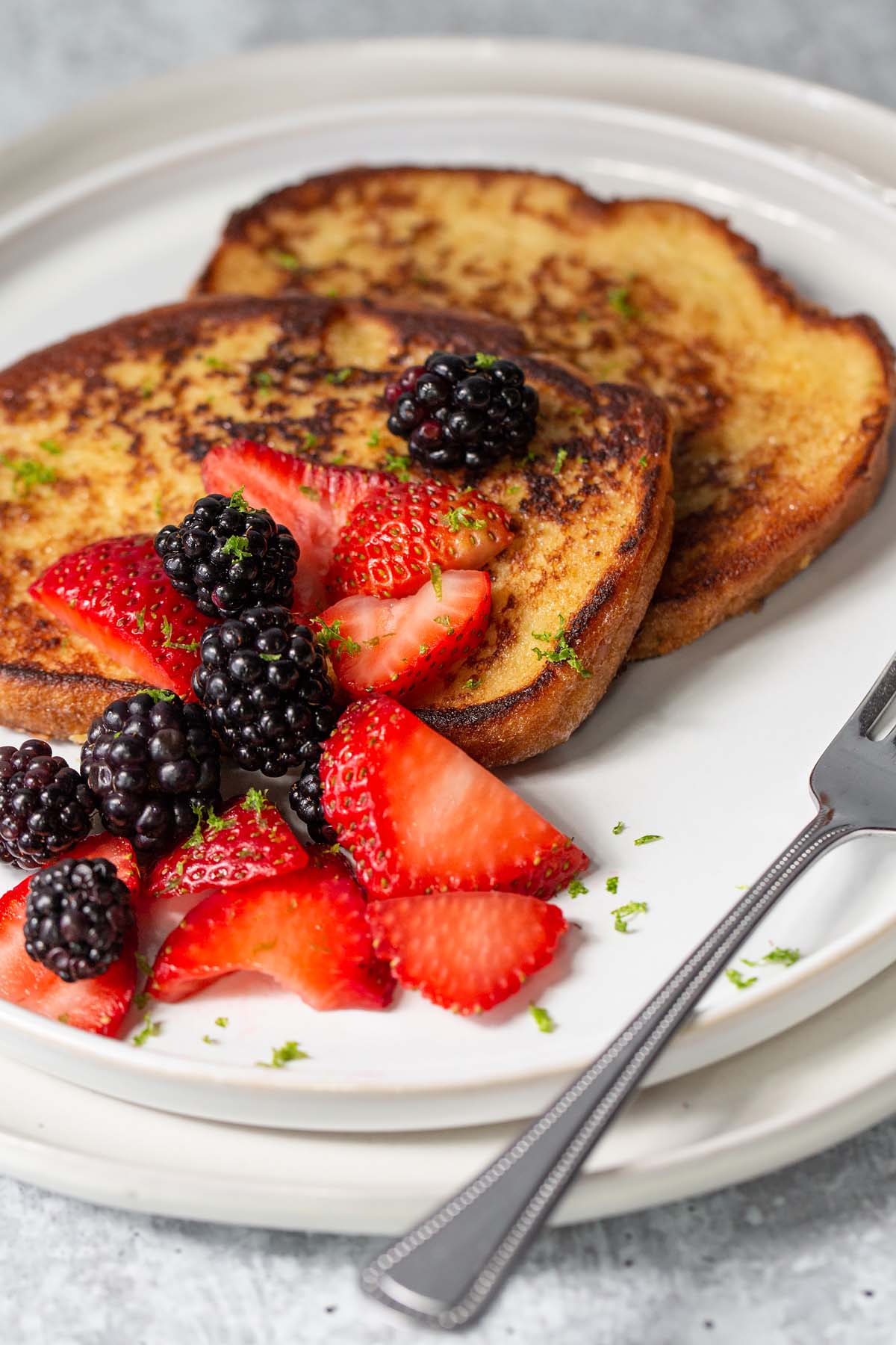 french toast topped with blackberries and sliced strawberries