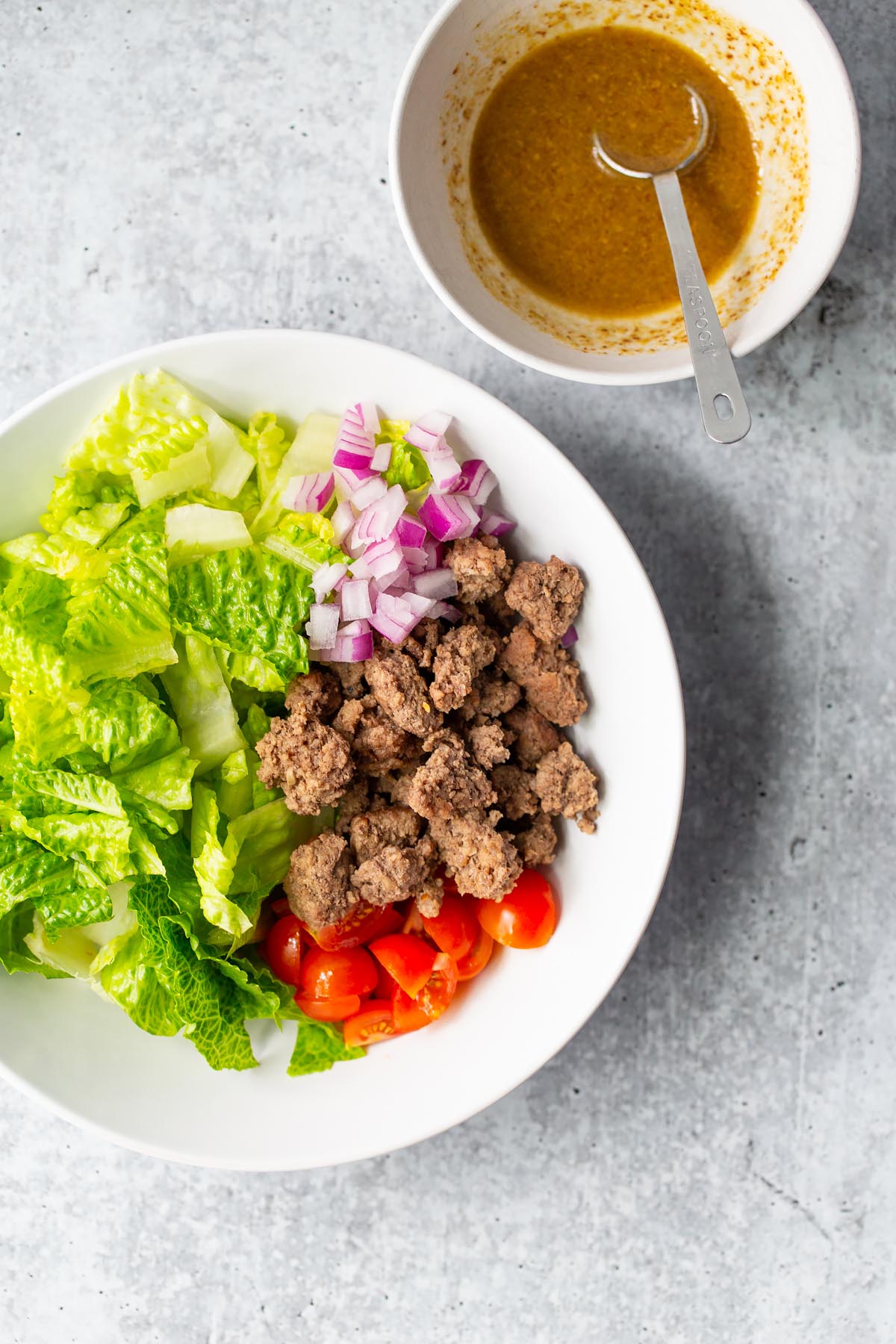 ingredients in a bowl with dressing on the side