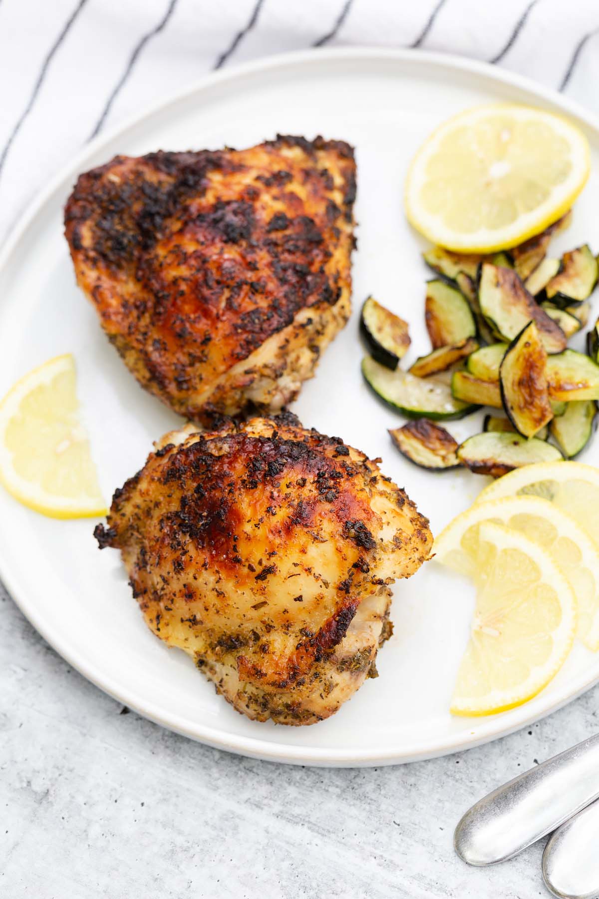 greek chicken thighs with lemon slices and cooked zucchini slices