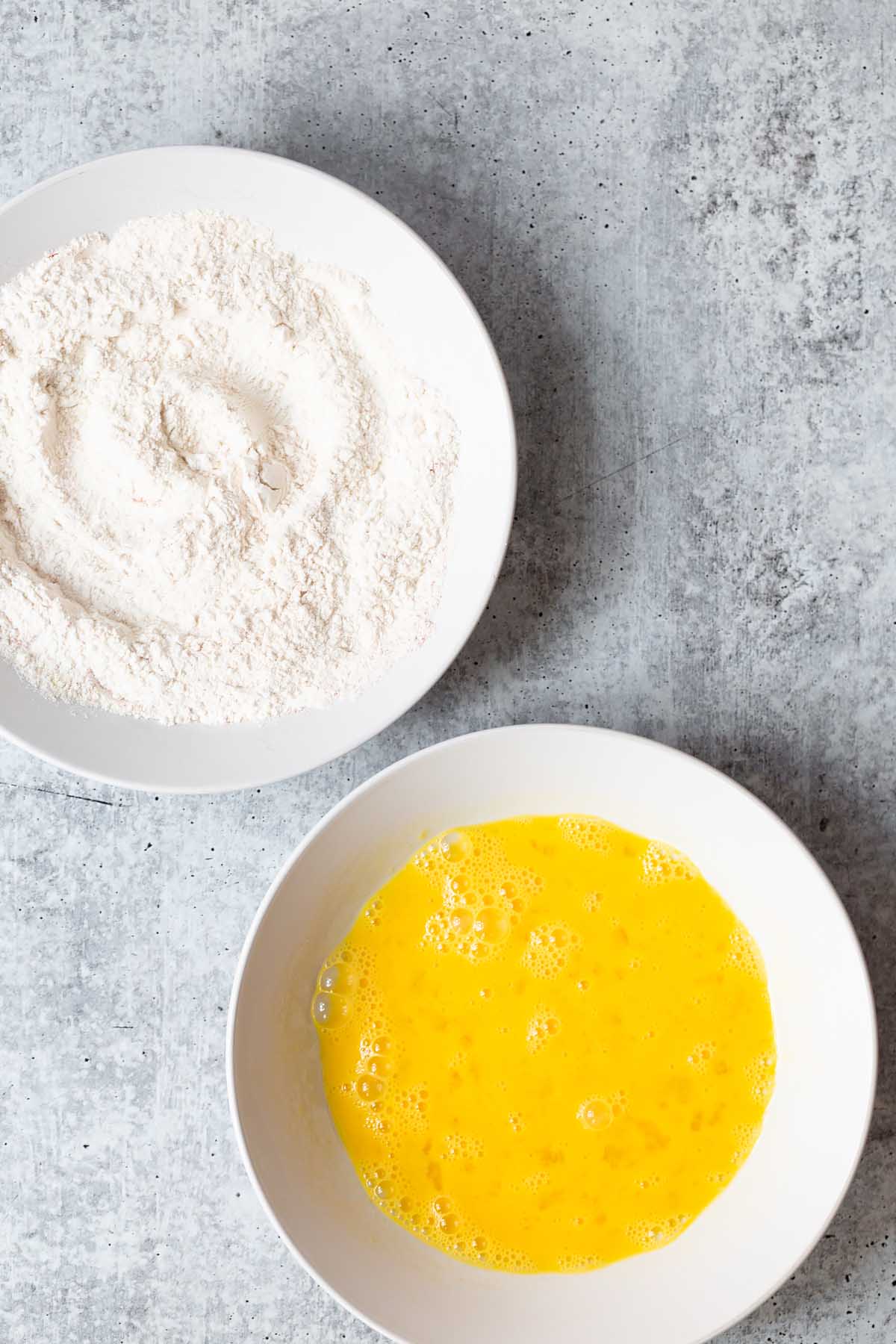 bowl of flour and bowl of beaten eggs