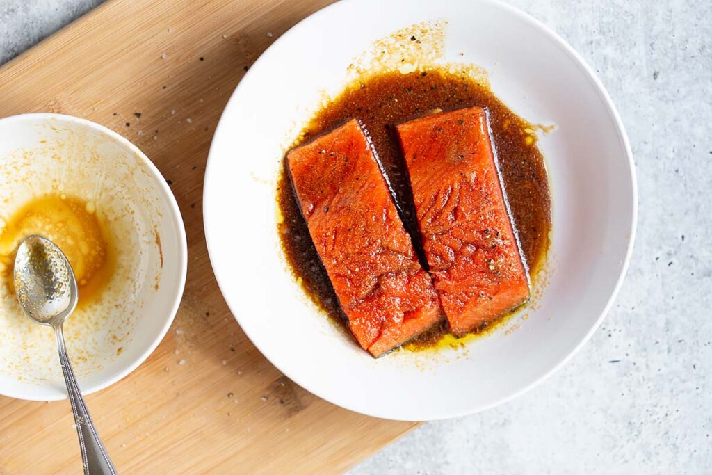 Two salmon pieces in marinade.