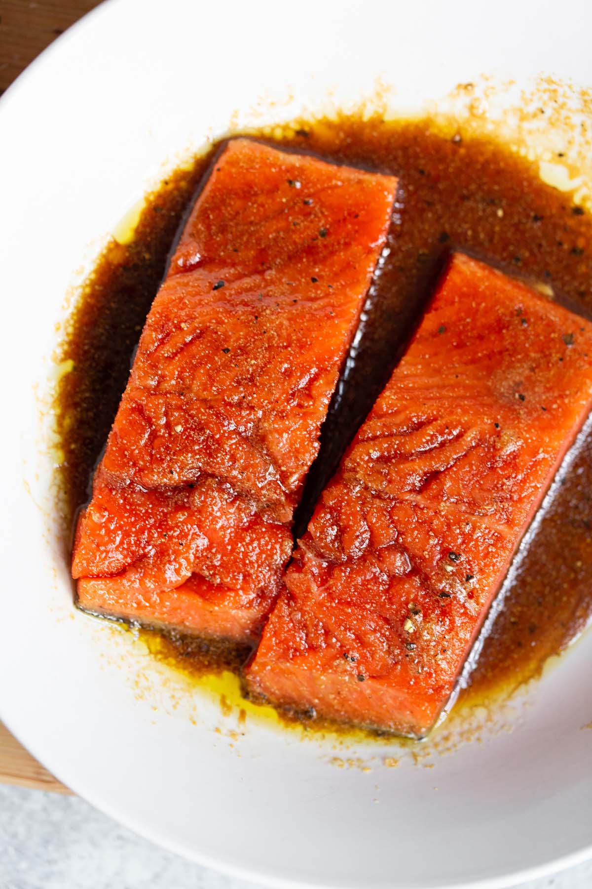 Two salmon pieces in marinade.