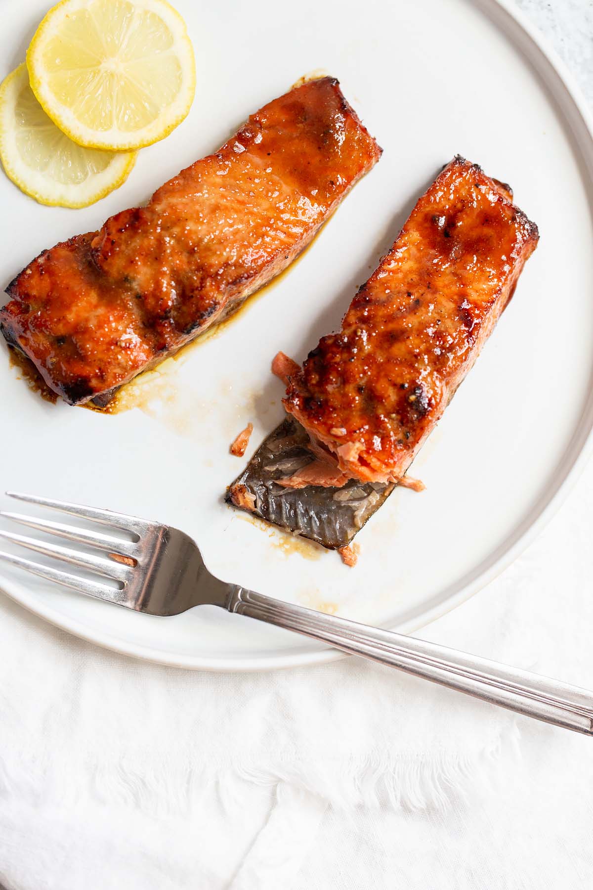 Two pieces of cooled salmon, one with a bite taken out.