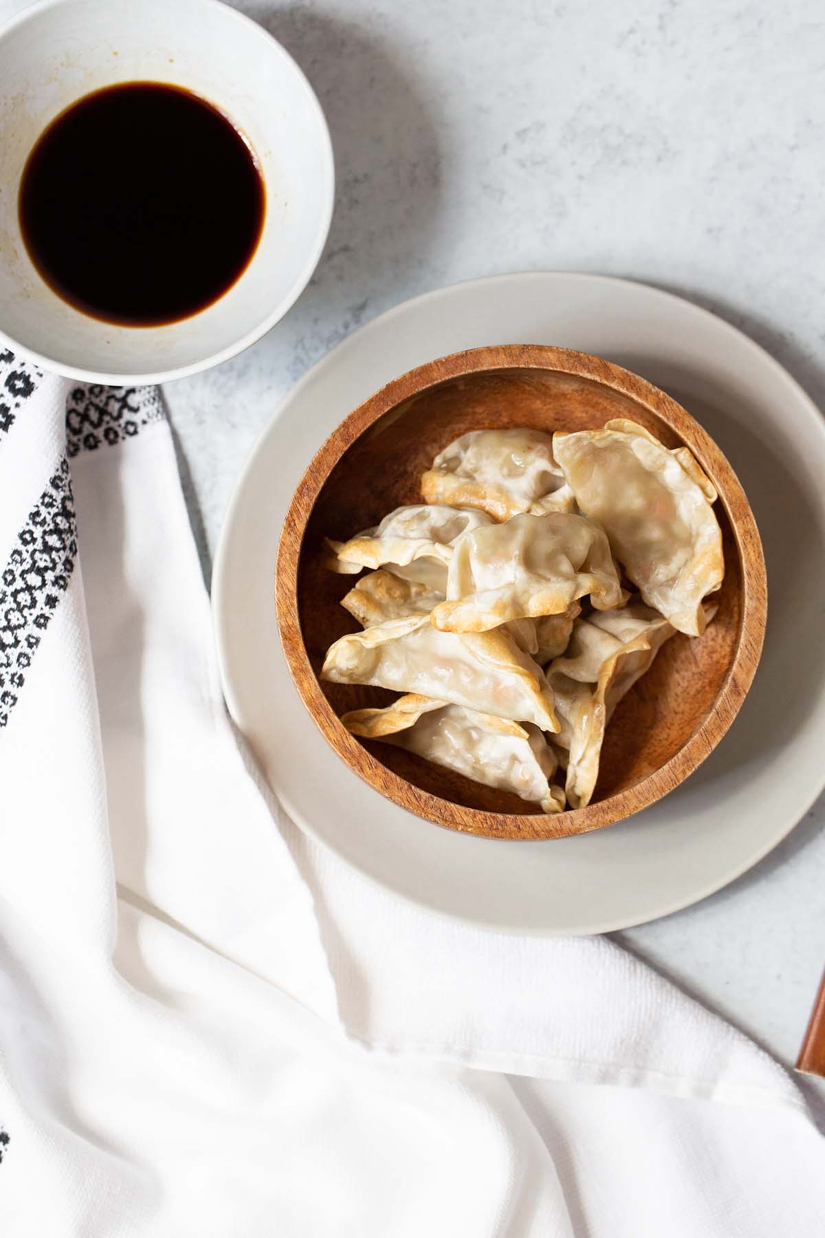 potstickers in a bowl with sauce on the side