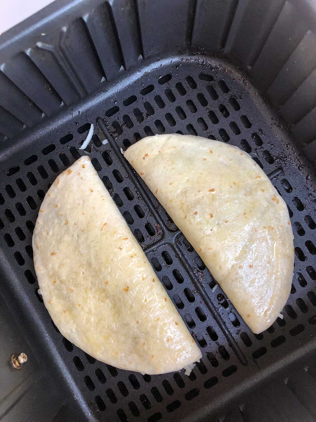 uncooked quesadilla in air fryer basket