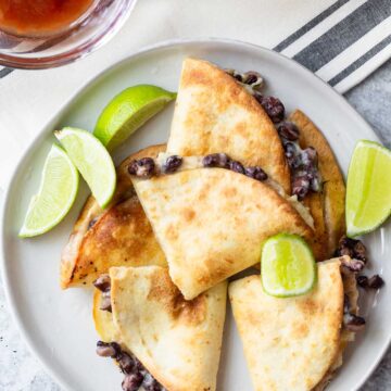 quesadillas on a plate with lime wedges