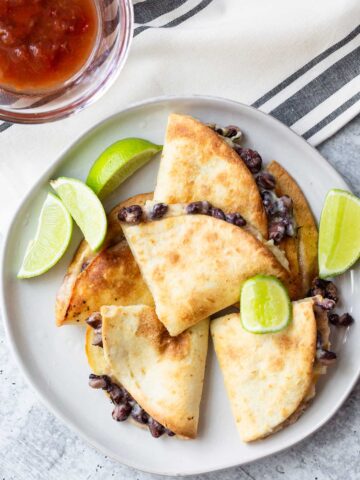 quesadillas on a plate with lime wedges