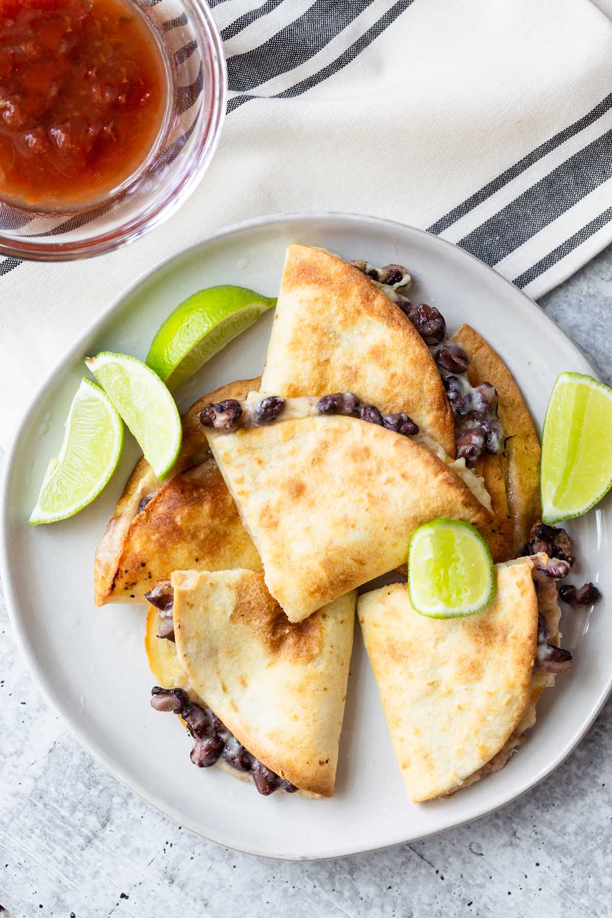 quesadillas on a plate with lime wedges