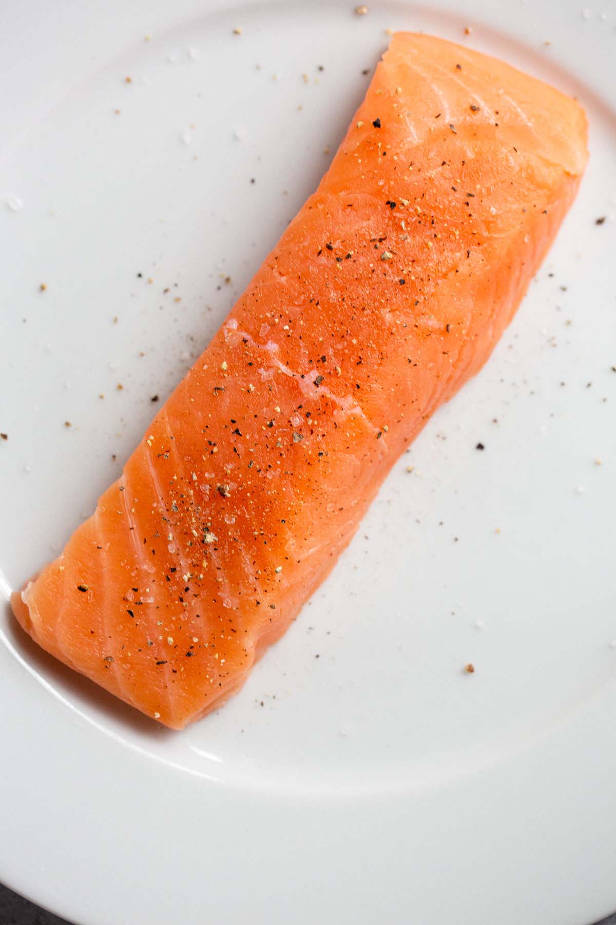 Uncooked salmon seasoned with salt and pepper.