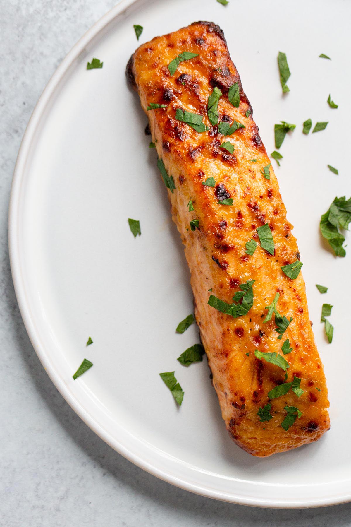 Air fryer honey dijon salmon on a plate with parsley.