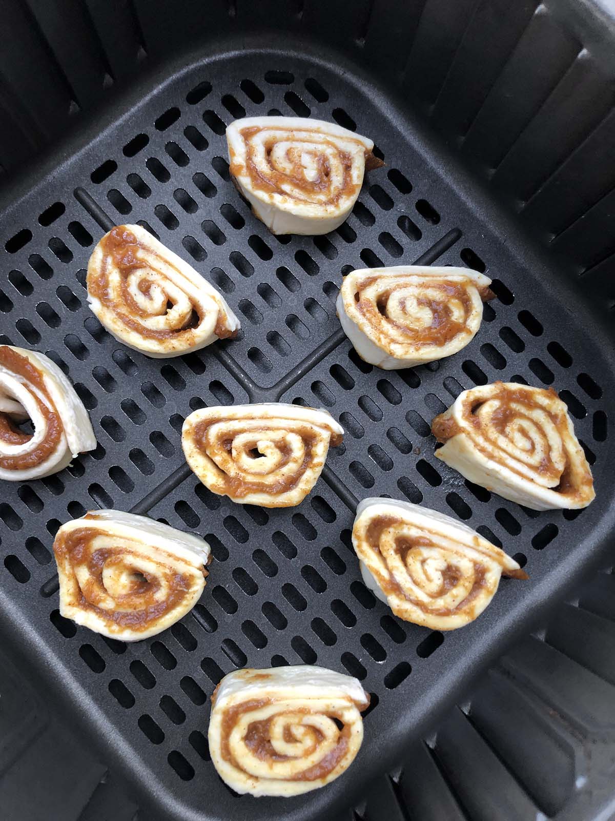 uncooked pumpkin pinwheels in air fryer basket