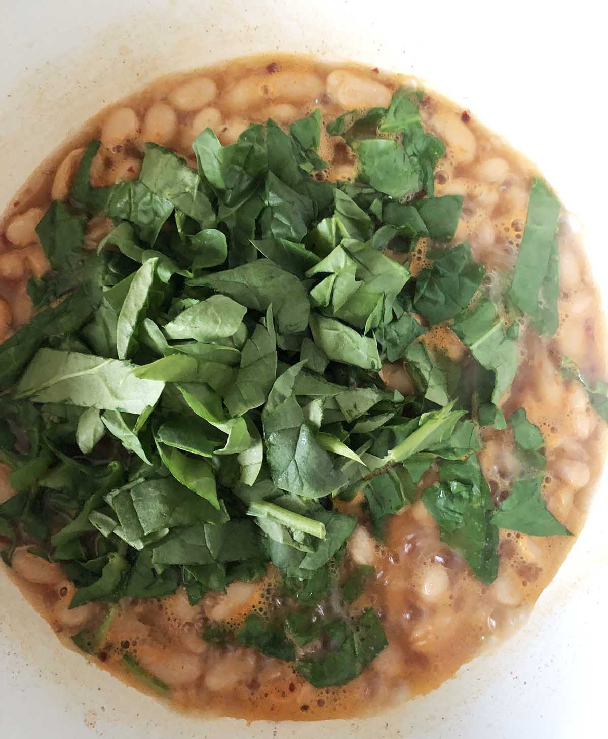 adding spinach to beans