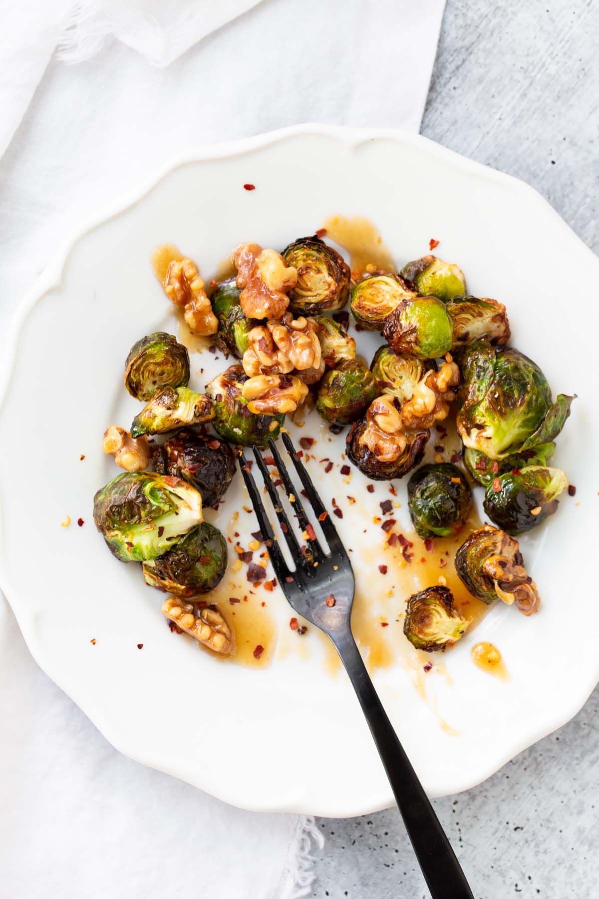 brussels sprouts with a fork sprinkled with chili flakes