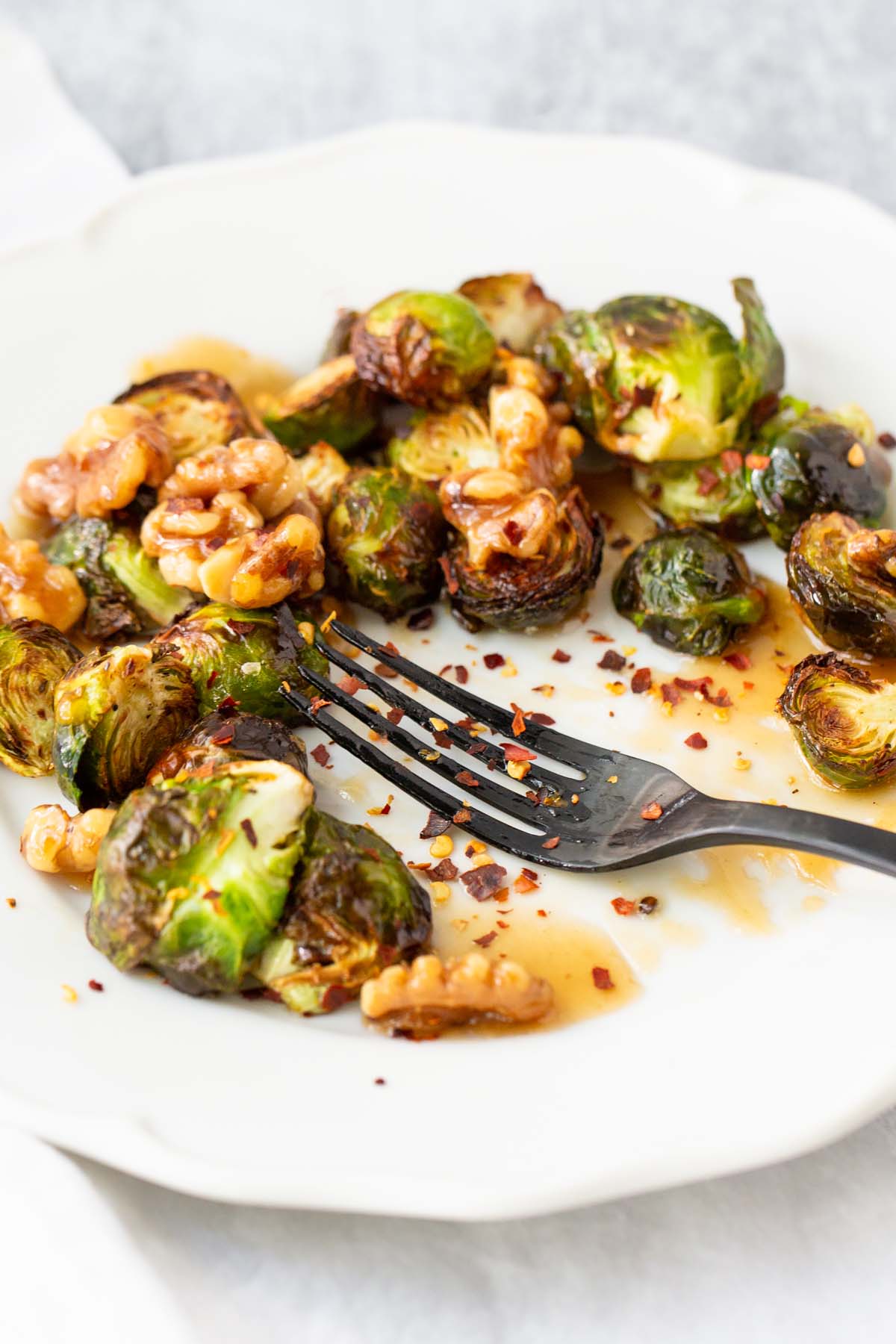 brussels sprouts with a fork sprinkled with chili flakes