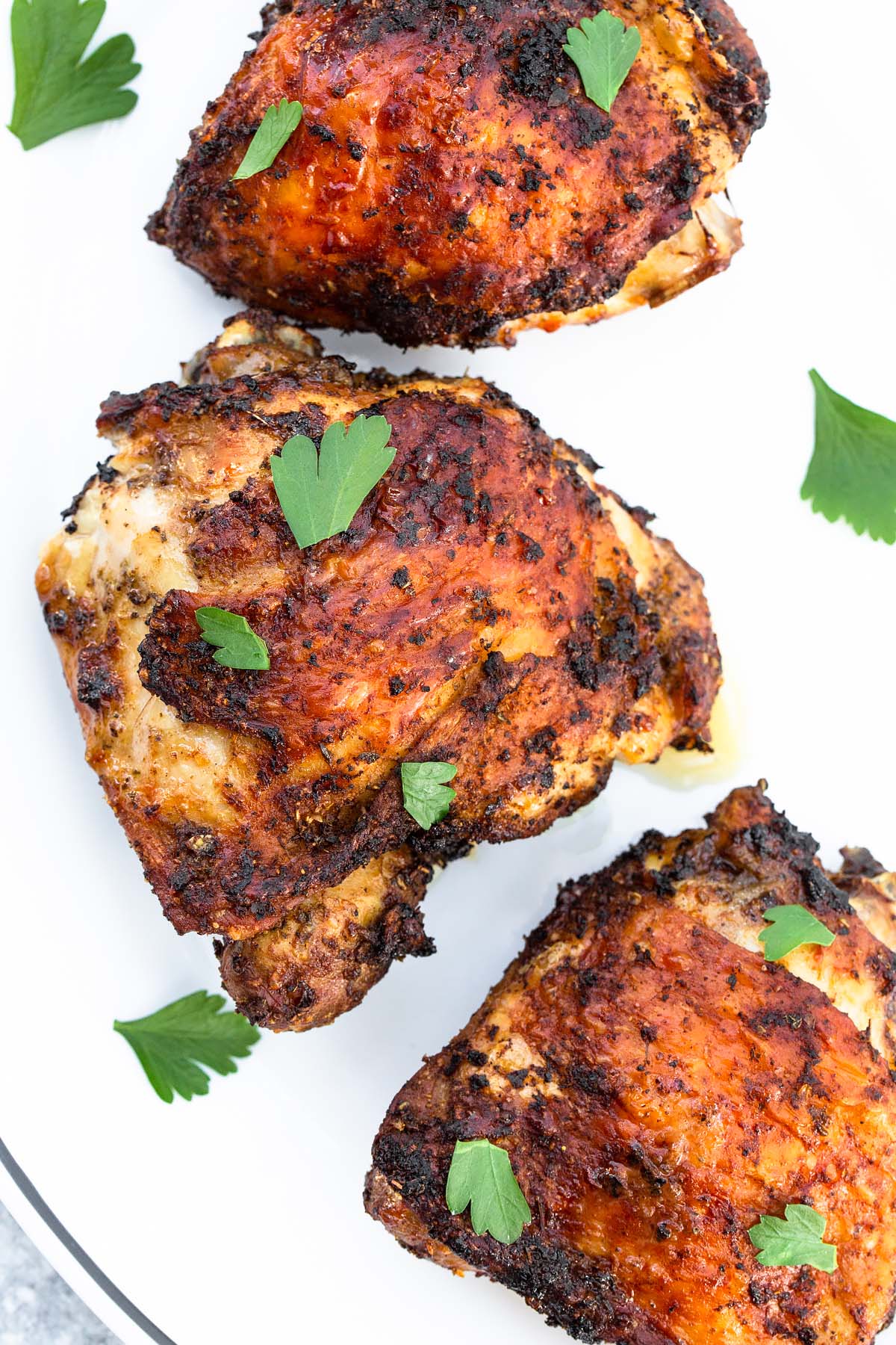 chicken thighs on a plate with parsley up close