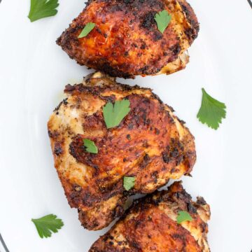 chicken thighs on a plate with parsley