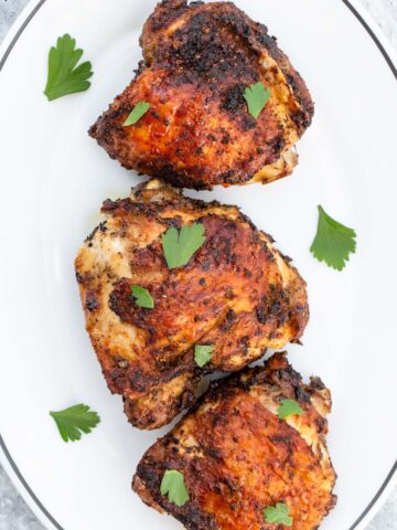 chicken thighs on a plate with parsley