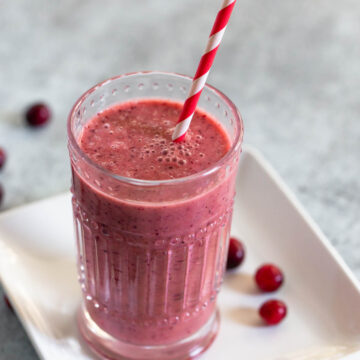 cranberry smoothie with a red and white striped straw