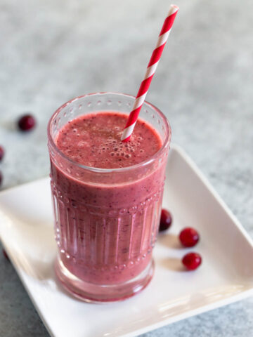 cranberry smoothie with a red and white striped straw
