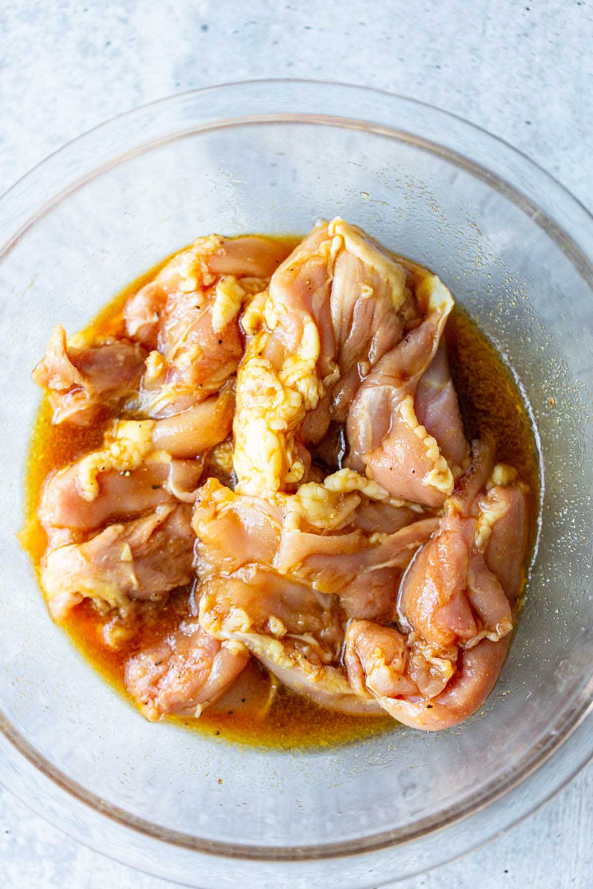 chicken thighs in a bowl with marinade
