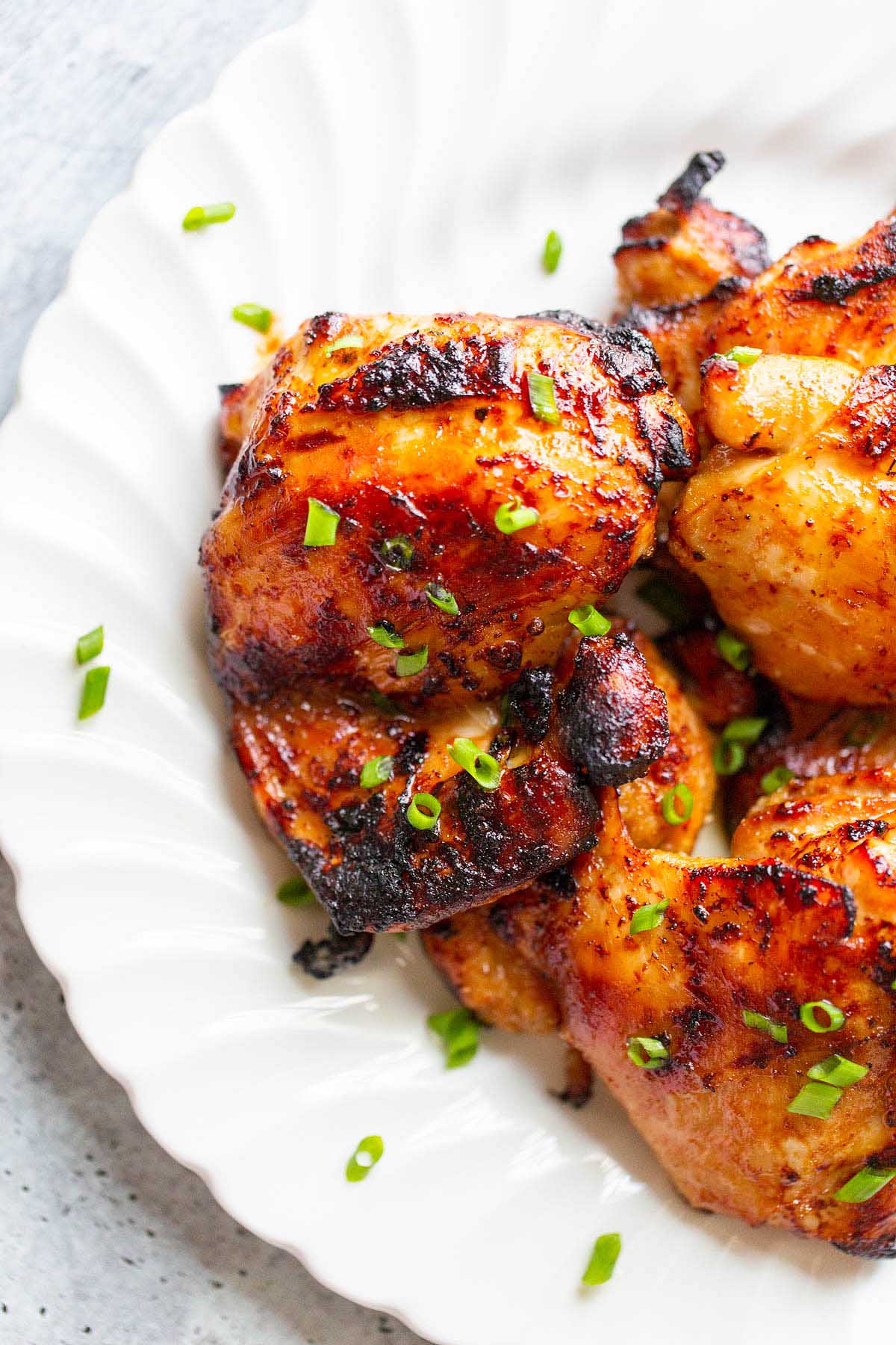 chicken thighs on a plate topped with green onions