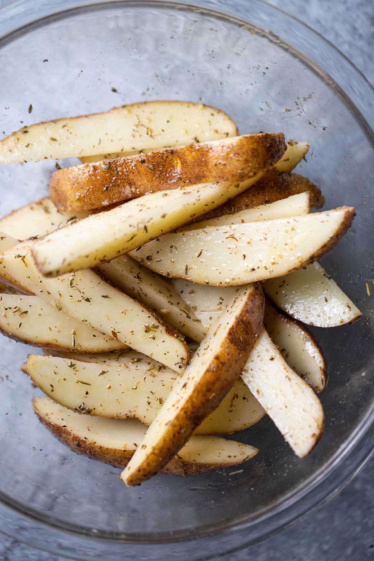 uncooked french fries in a glass bowl.