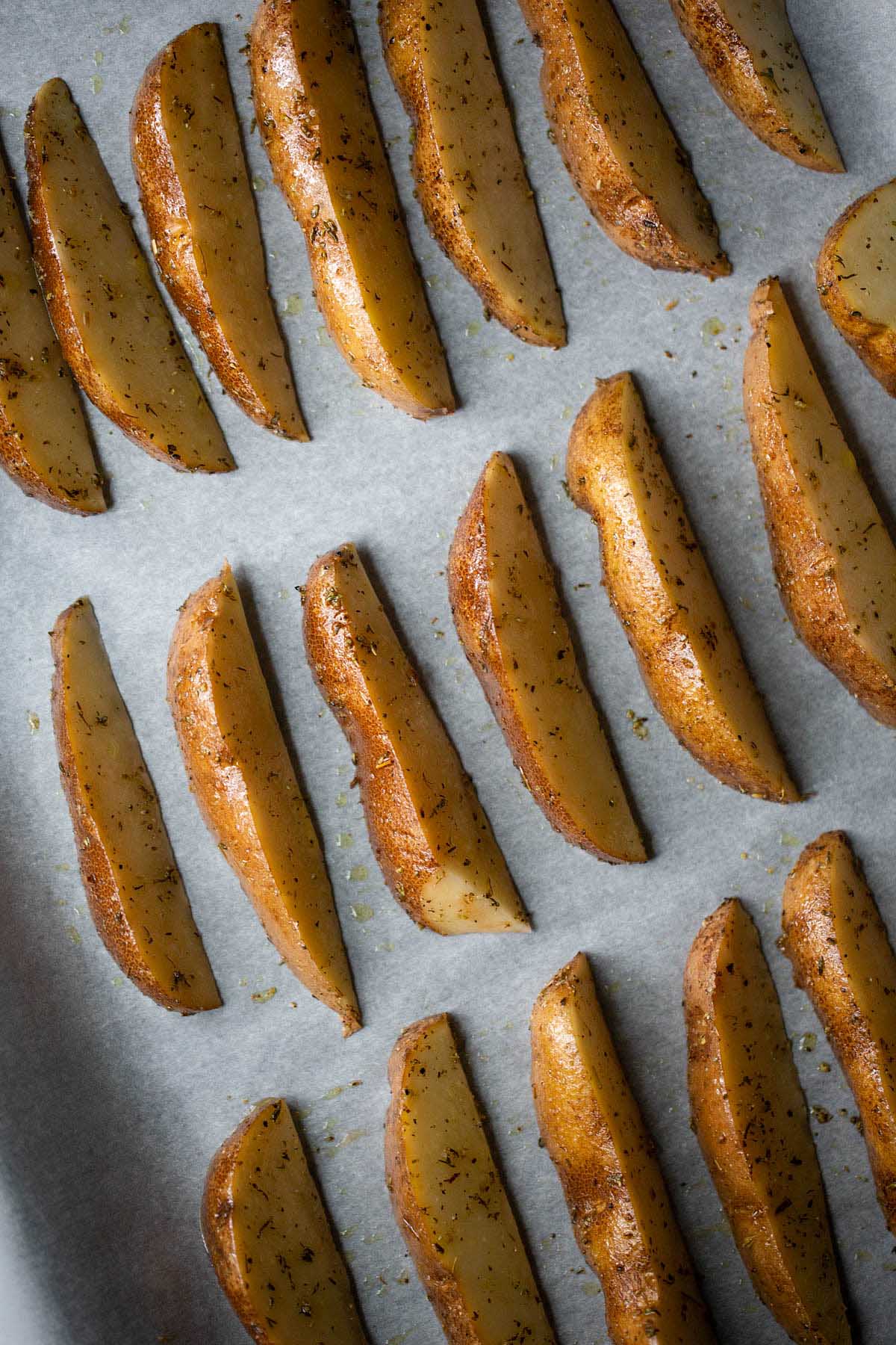 uncooked french fries on a baking sheet.