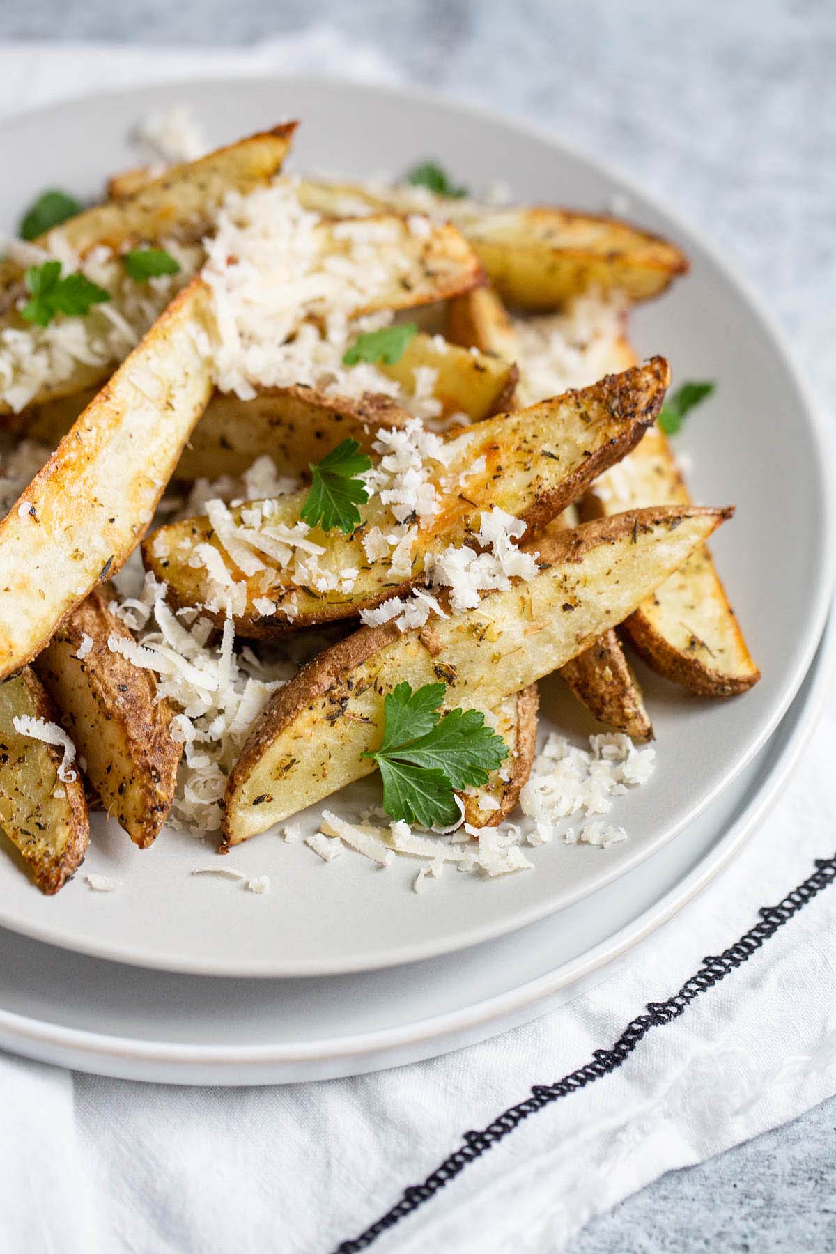 french fries topped with parmesan cheese and parsley.