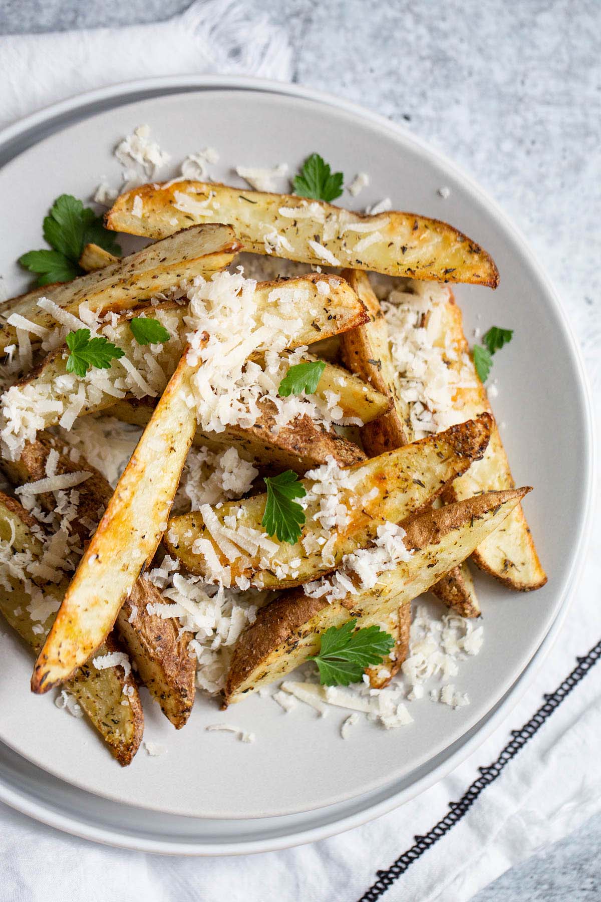french fries topped with parmesan cheese and parsley.