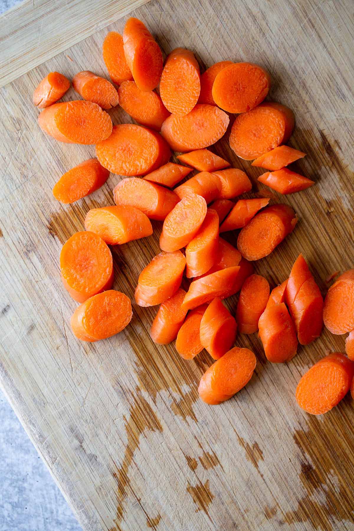 sliced carrots on a wooden cutting board.