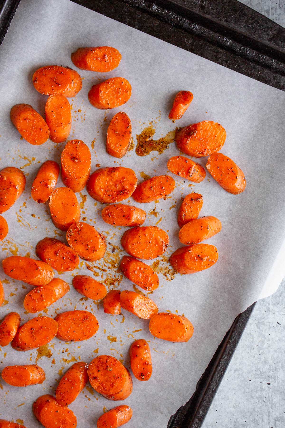 raw sliced carrots on a cookie sheet.