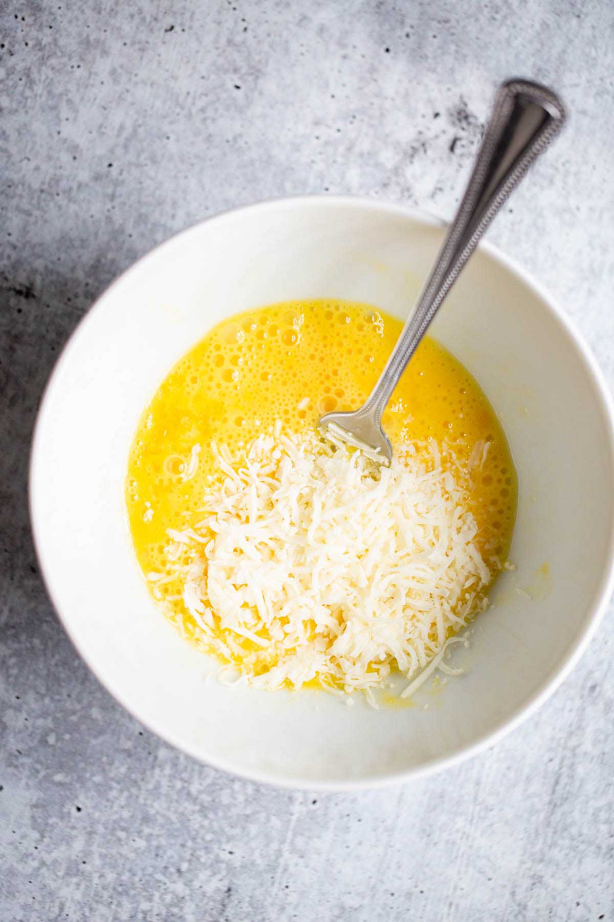 raw eggs and cheese in a white bowl