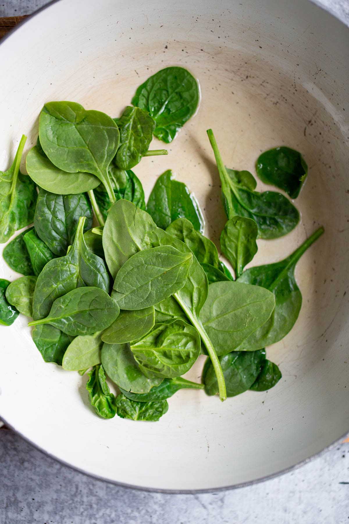 raw spinach in a skillet