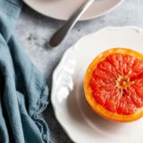 cooked grapefruit on plates with a blue towel on the side.
