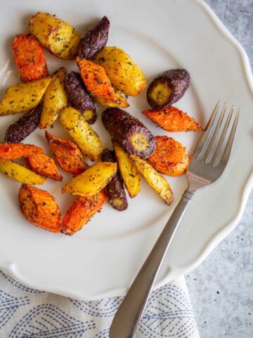 Cooked rainbow carrots on a plate.