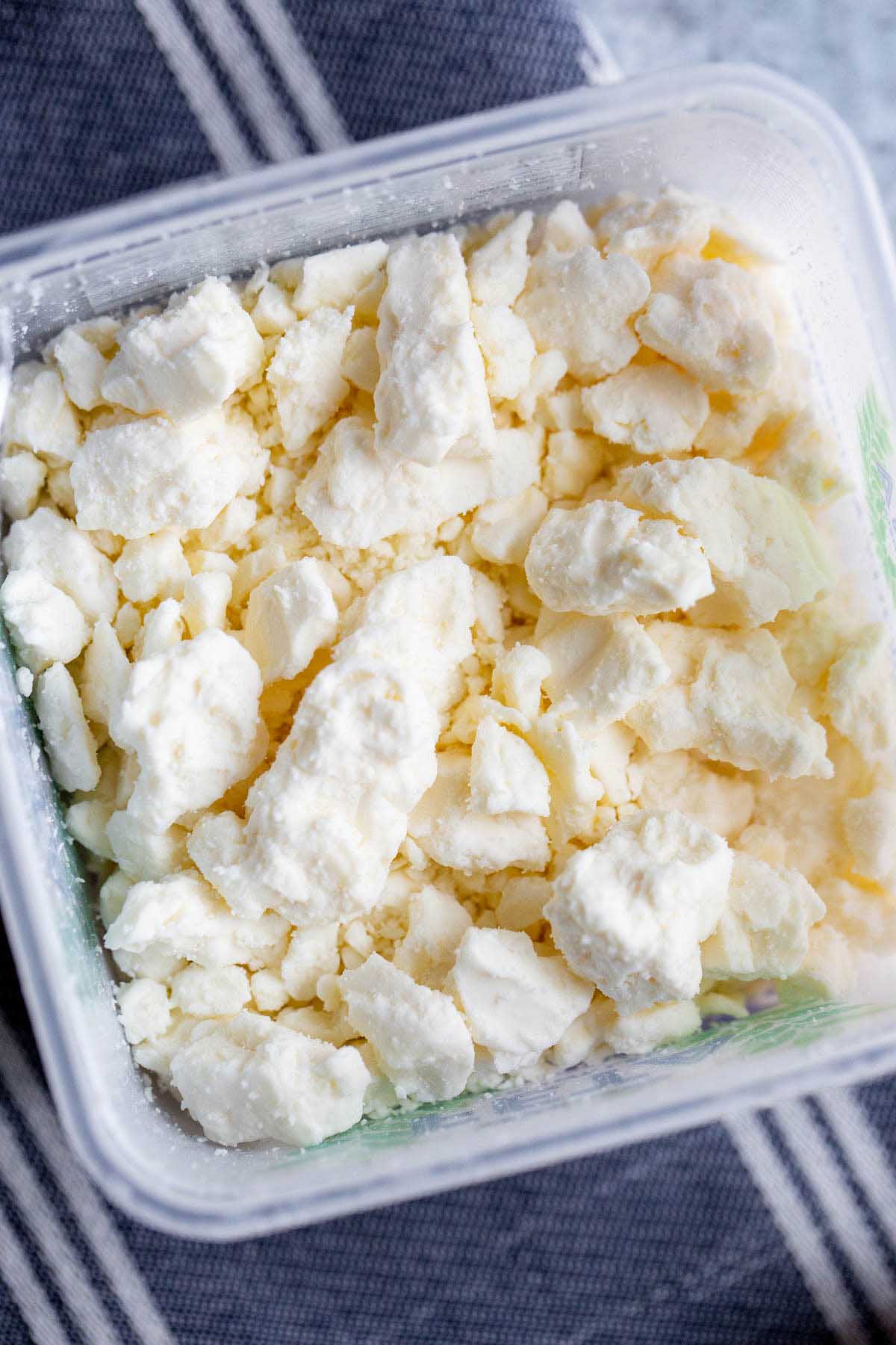 Crumbled feta in a container.